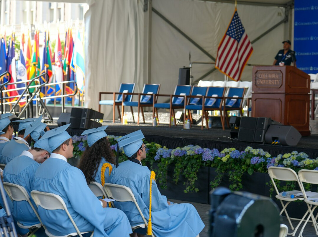 Moderator addressing a panel of seated speakers on stage
